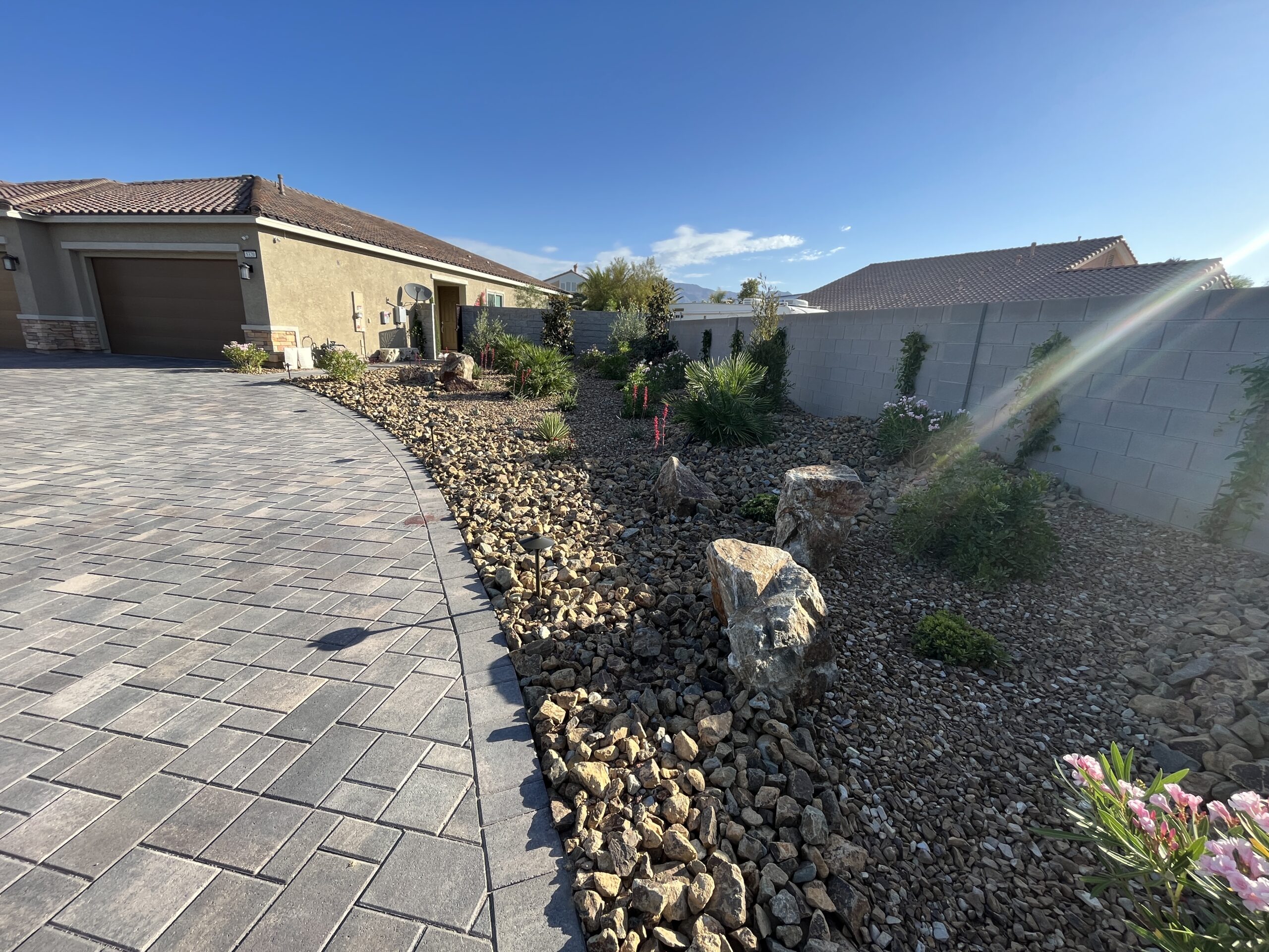 A driveway with rocks and plants in it