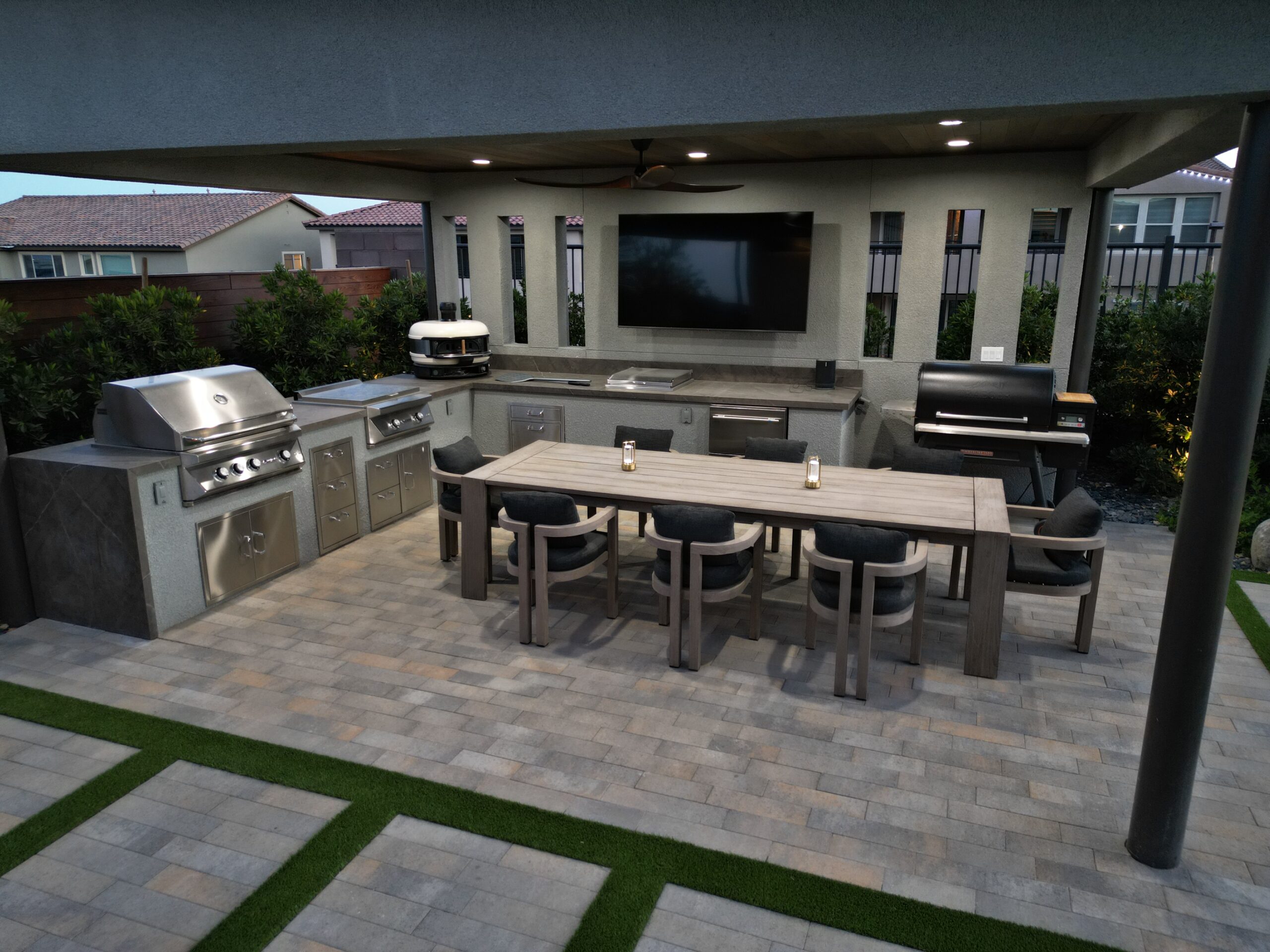 A large outdoor kitchen with an entertainment center.