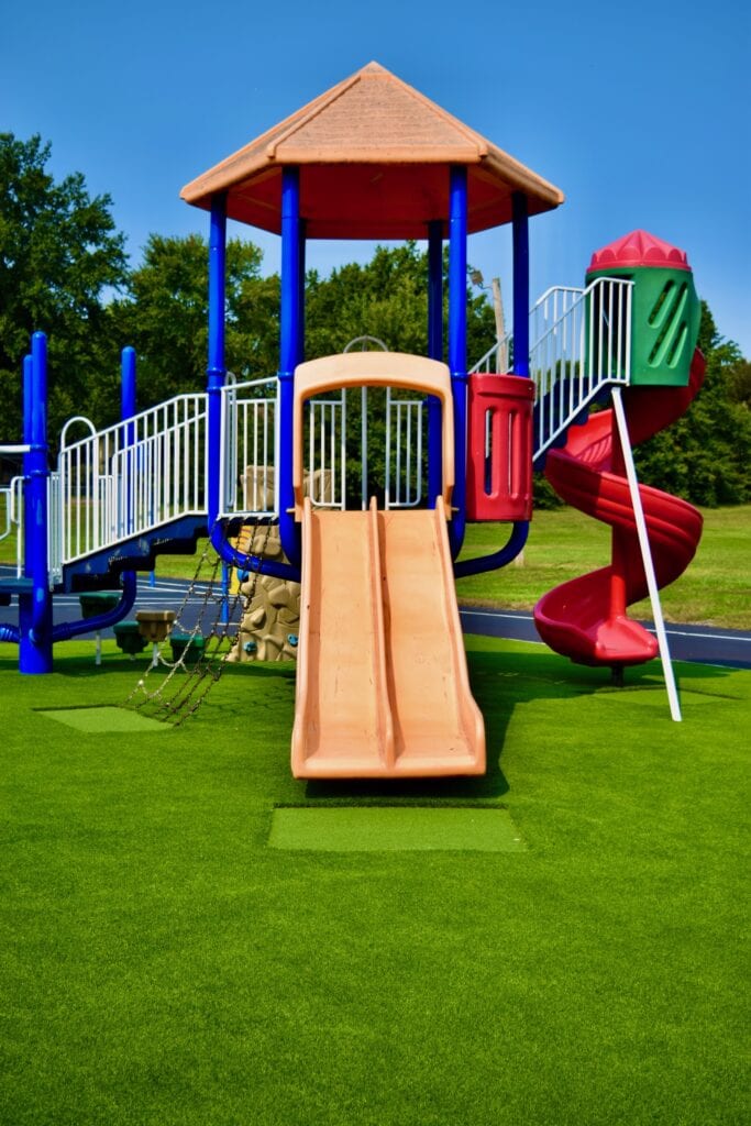 A playground with slides and swings for children.