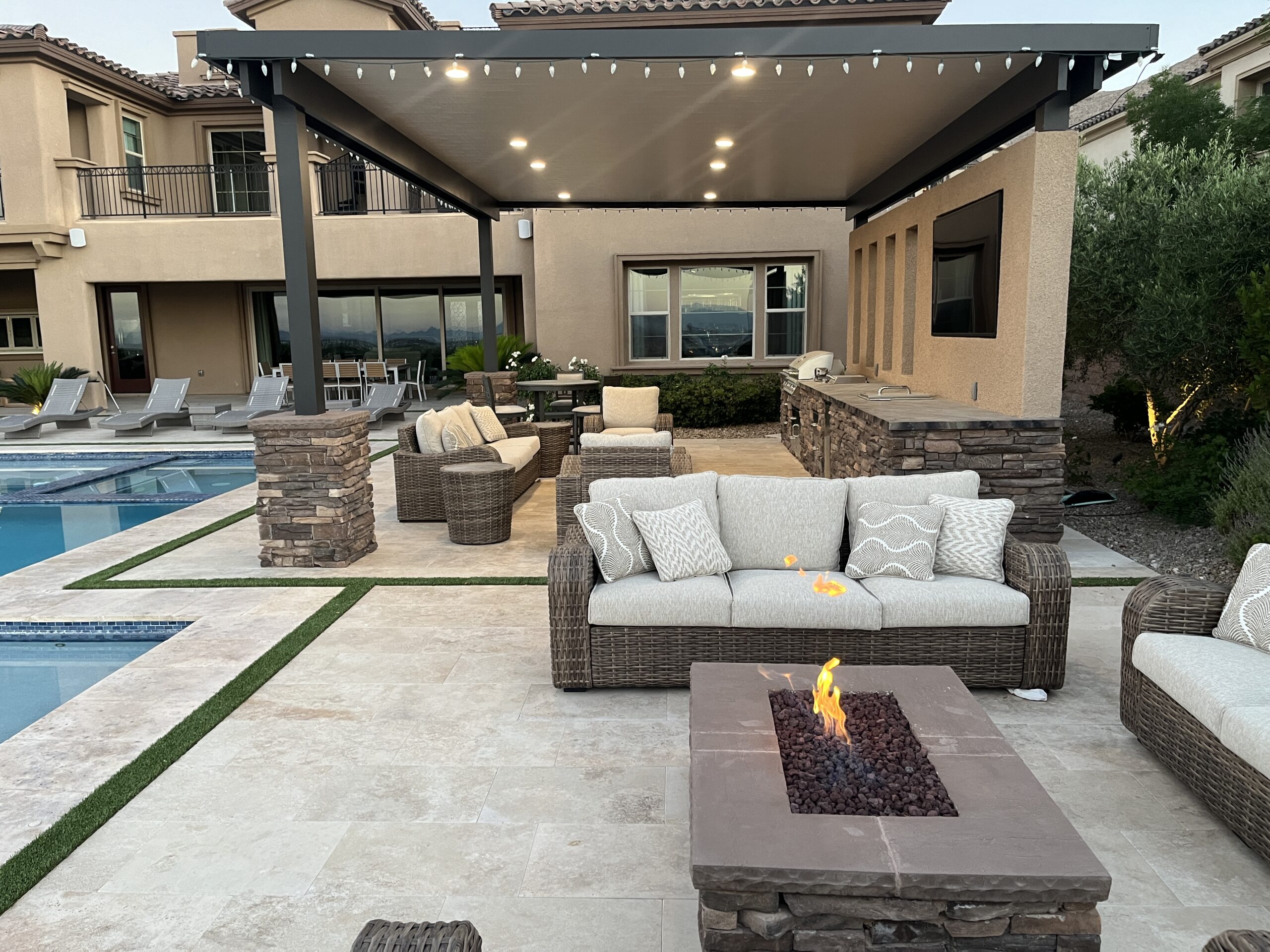 A patio with fire pit and couch in it