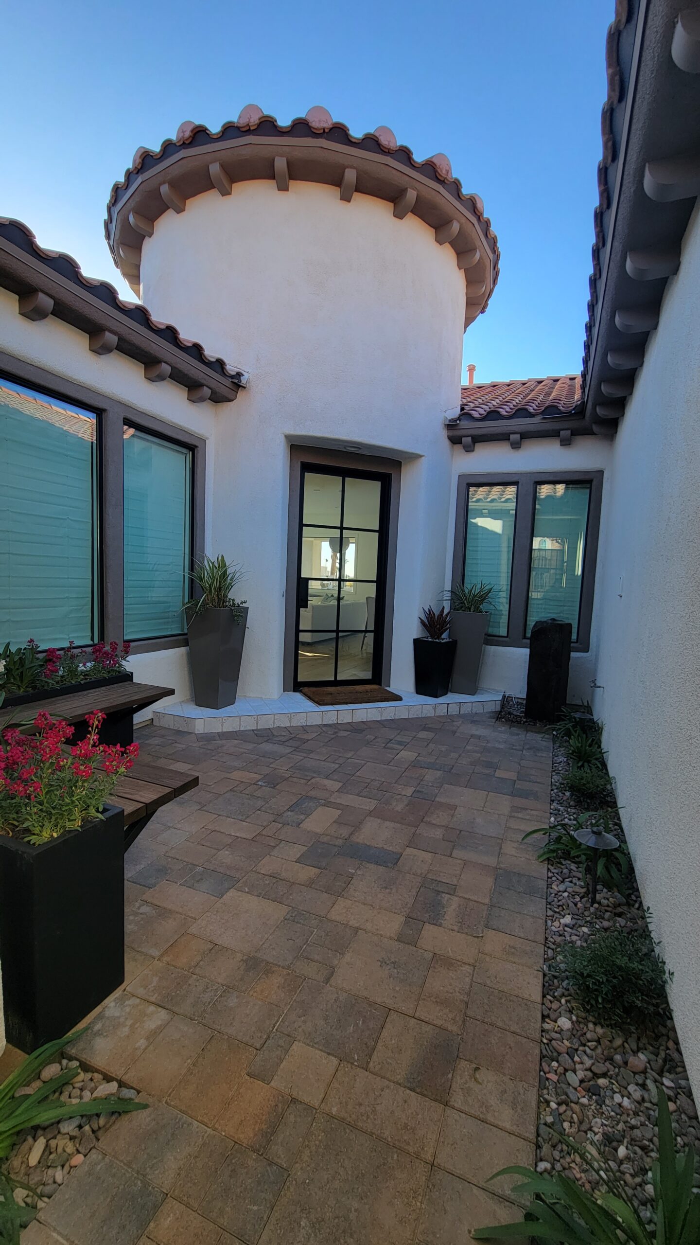 A patio with potted plants and a door.