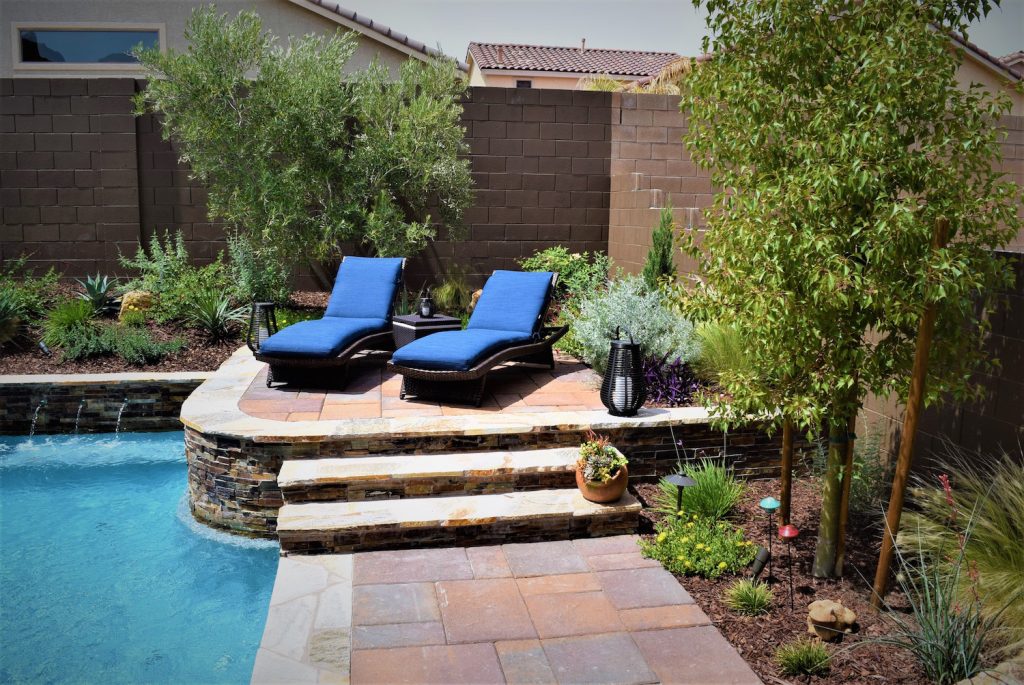 Two lounge chairs are sitting on the side of a pool.