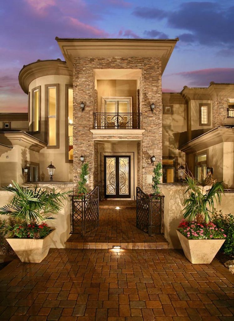 A large house with potted plants and lights